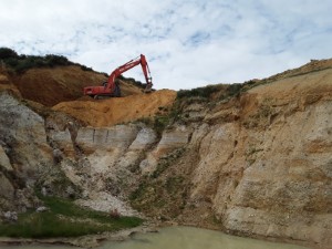 Large excavator clearing for mining further away